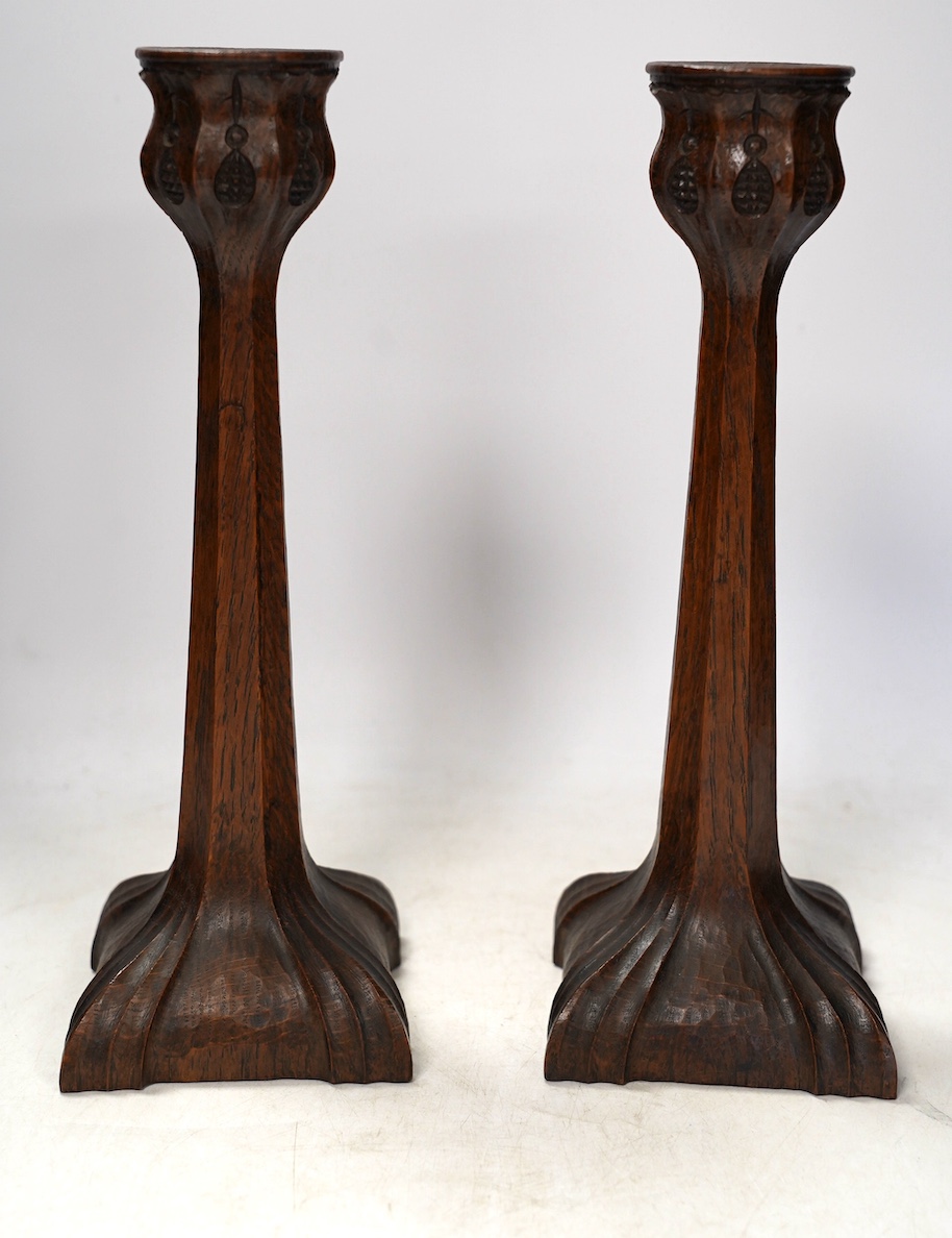 A pair of Arts and Crafts carved oak candlesticks, 28cm. Condition - good